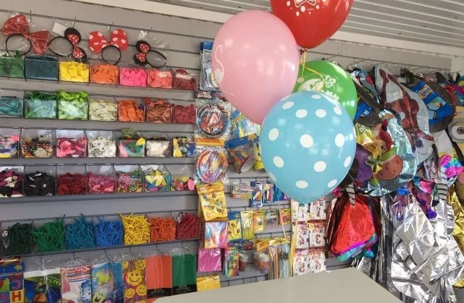 Магазин гелевых шаров. Витрина для воздушных шаров. Товары для праздника. Оборудование для магазина воздушных шаров. Выкладка воздушных шаров в магазине.