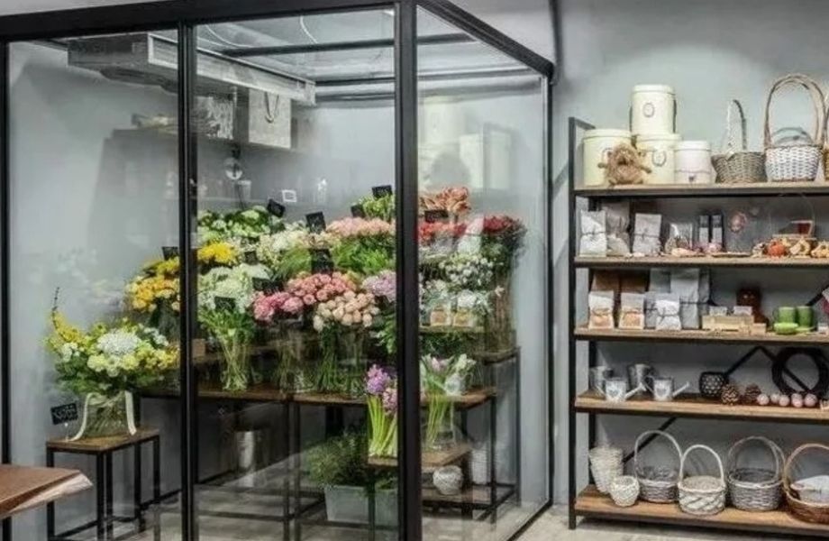 Магазин цветов из витринного окна которого виден весь холодильник